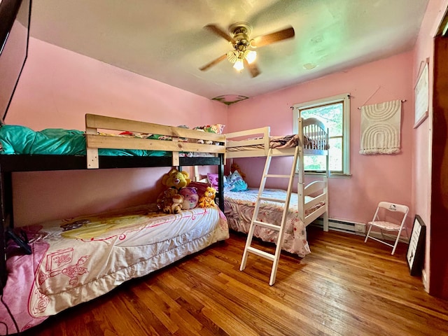 10070 Wolfe Rd, New Vienna, OH 45159 - bedroom featuring wood finished floors, ceiling fan, and a baseboard heating unit