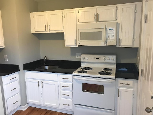 2649 Hiawatha St, Columbus, OH 43211 - kitchen with white appliances, a sink, dark countertops, and white cabinets