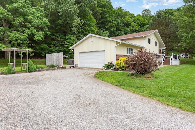 2914 Hickory Hill Dr SE, Lancaster, OH 43130 - view of side of home with driveway, a garage, a yard, and a wooded view