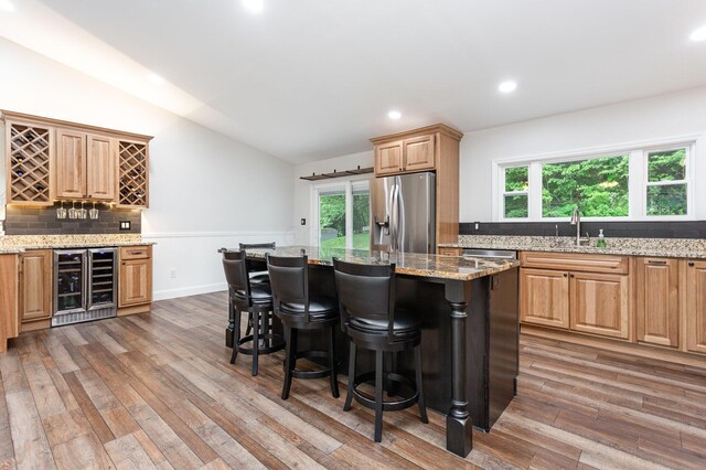2914 Hickory Hill Dr SE, Lancaster, OH 43130 - kitchen with beverage cooler, appliances with stainless steel finishes, a sink, a kitchen bar, and lofted ceiling