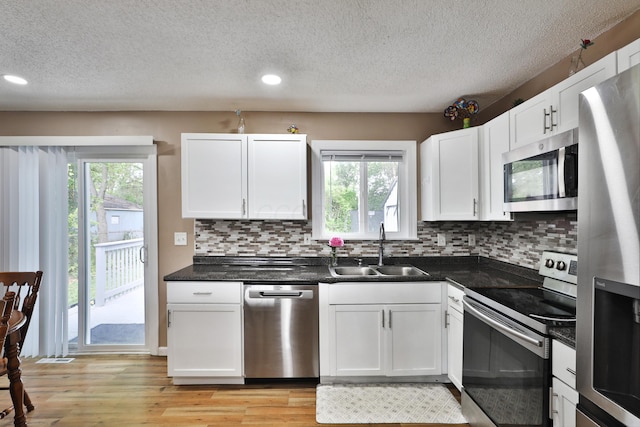 4511 Collingdale Rd, Columbus, OH 43231 - kitchen with appliances with stainless steel finishes, a sink, light wood finished floors, backsplash, and white cabinets