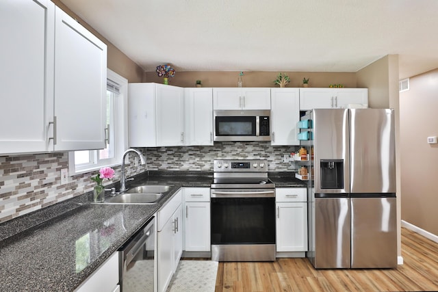 4511 Collingdale Rd, Columbus, OH 43231 - kitchen with appliances with stainless steel finishes, a sink, light wood finished floors, white cabinetry, and decorative backsplash