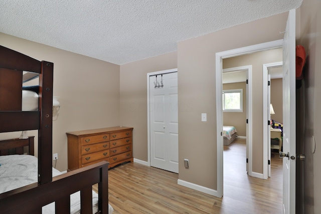 4511 Collingdale Rd, Columbus, OH 43231 - bedroom featuring light wood finished floors, a textured ceiling, baseboards, and a closet