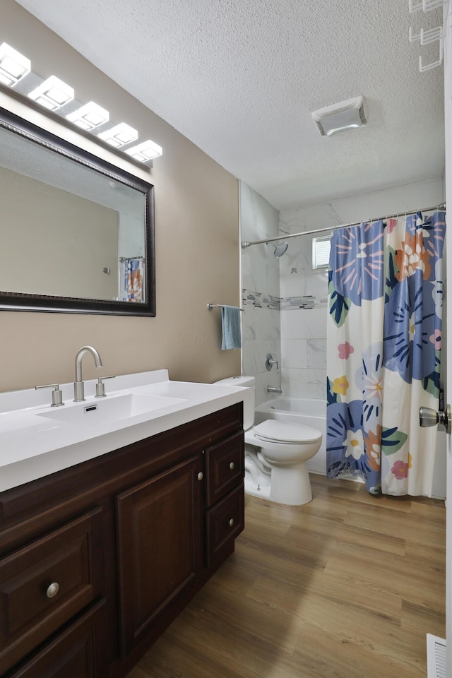 4511 Collingdale Rd, Columbus, OH 43231 - full bathroom featuring a textured ceiling, wood finished floors, toilet, vanity, and shower / bath combo