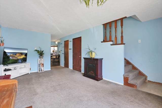 7347 Fall Creek Ln Unit J, Columbus, OH 43235 - living room with stairway, a textured ceiling, carpet floors, a fireplace, and baseboards