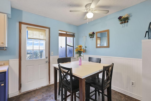 7347 Fall Creek Ln Unit J, Columbus, OH 43235 - dining area featuring a wainscoted wall, a ceiling fan, and a textured ceiling
