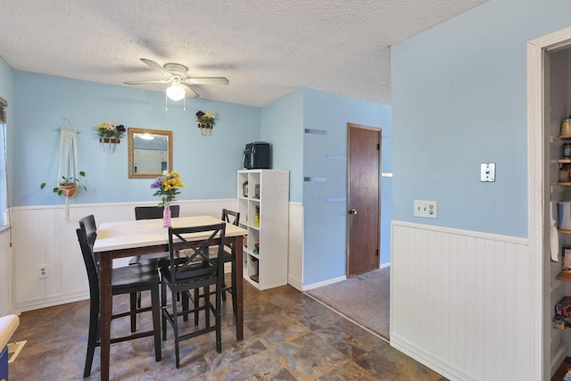 7347 Fall Creek Ln Unit J, Columbus, OH 43235 - dining area featuring a wainscoted wall, ceiling fan, and a textured ceiling