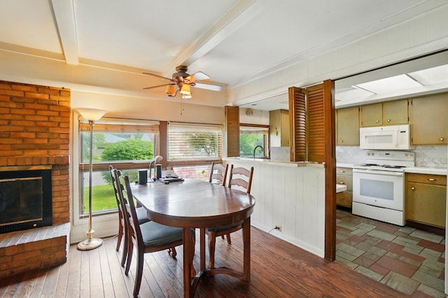 1120 Morning St, Worthington, OH 43085 - dining room featuring beam ceiling, dark wood-type flooring, ceiling fan, and a fireplace