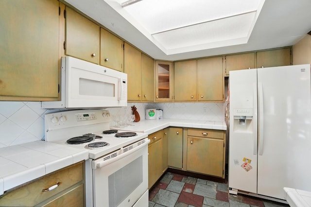 1120 Morning St, Worthington, OH 43085 - kitchen featuring white appliances, backsplash, tile countertops, and glass insert cabinets