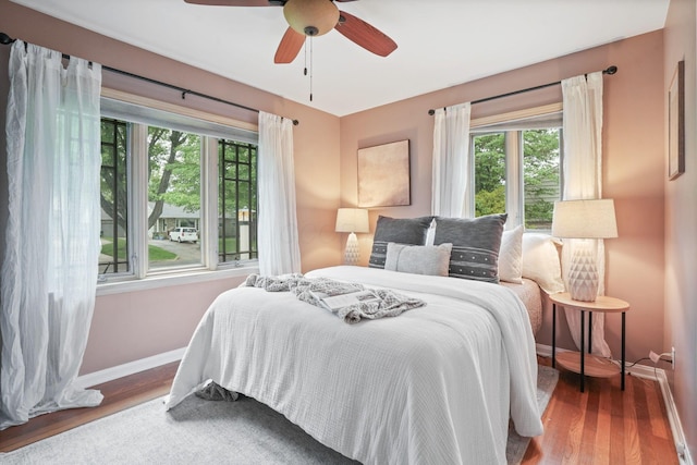 2314 Woodstock Rd, Columbus, OH 43221 - bedroom with baseboards, multiple windows, wood finished floors, and a ceiling fan