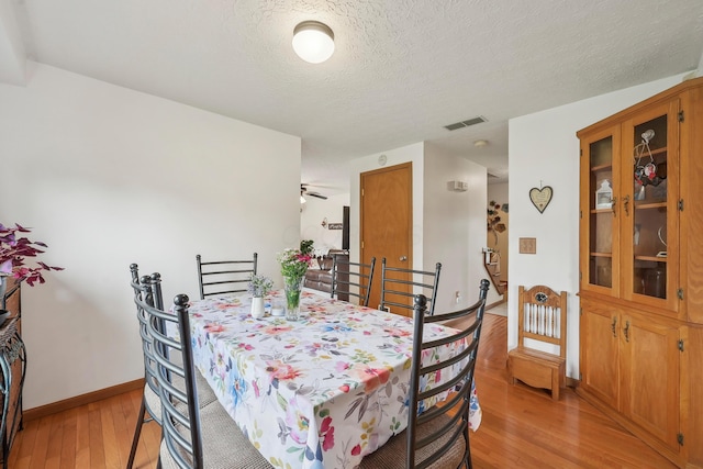 5046 Rolling Rock Ct, Columbus, OH 43229 - dining space with light wood-type flooring, baseboards, and a textured ceiling