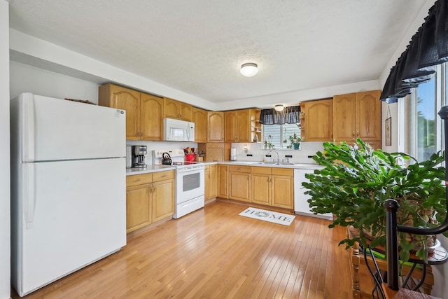 5046 Rolling Rock Ct, Columbus, OH 43229 - kitchen featuring white appliances, light countertops, light wood-type flooring, a sink, and a textured ceiling