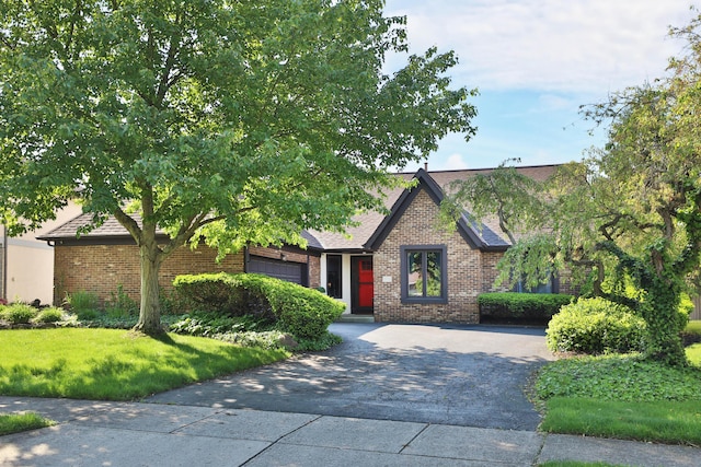 7775 Pembrook Dr, Reynoldsburg, OH 43068 - view of front of house featuring asphalt driveway, brick siding, a front lawn, and roof with shingles