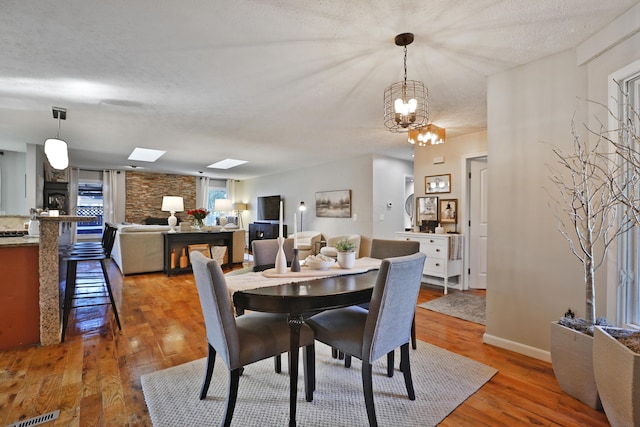 7775 Pembrook Dr, Reynoldsburg, OH 43068 - dining room with light wood finished floors, baseboards, a skylight, and a chandelier