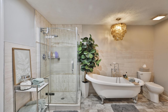 7775 Pembrook Dr, Reynoldsburg, OH 43068 - full bath featuring a stall shower, tile walls, a freestanding tub, toilet, and a chandelier