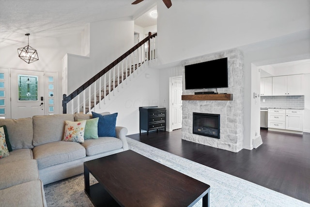 336 Saint Thomas Dr, Westerville, OH 43081 - living area with dark wood-style flooring, a ceiling fan, stairway, high vaulted ceiling, and a stone fireplace