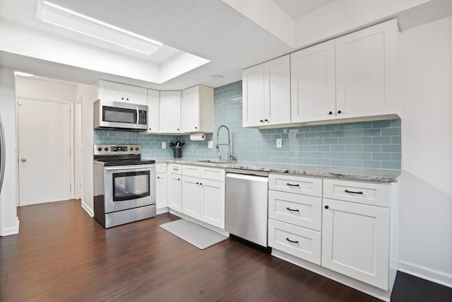 336 Saint Thomas Dr, Westerville, OH 43081 - kitchen featuring stainless steel appliances, a sink, dark wood-style floors, backsplash, and white cabinetry