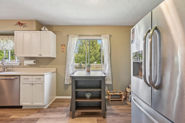 268 Southwood Rd, West Jefferson, OH 43162 - kitchen with appliances with stainless steel finishes, white cabinetry, light wood-style floors, and a textured ceiling