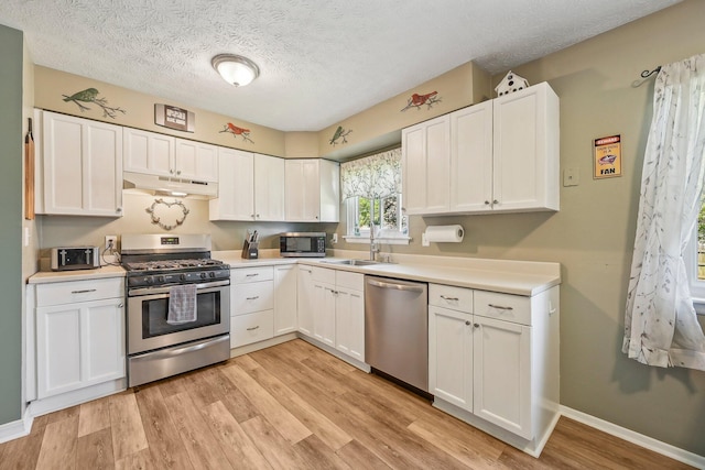268 Southwood Rd, West Jefferson, OH 43162 - kitchen featuring appliances with stainless steel finishes, under cabinet range hood, a sink, white cabinetry, and a textured ceiling