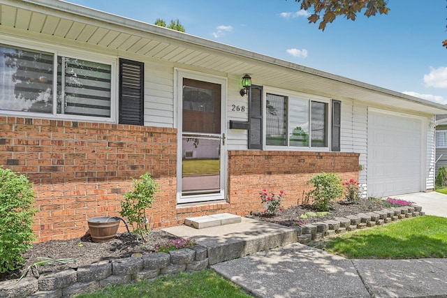 268 Southwood Rd, West Jefferson, OH 43162 - doorway to property with brick siding, a garage, covered porch, and driveway
