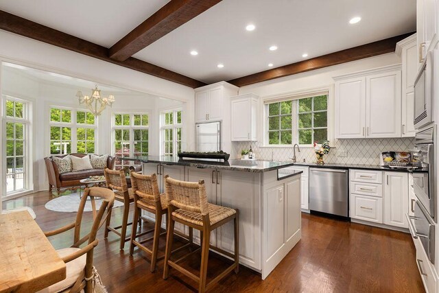 2989 Old Path Rd, Blacklick, OH 43004 - kitchen featuring appliances with stainless steel finishes, beamed ceiling, decorative backsplash, a breakfast bar area, and a chandelier