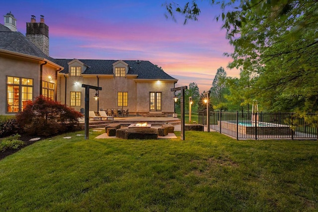 2989 Old Path Rd, Blacklick, OH 43004 - back of property at dusk with a fire pit, stucco siding, french doors, a patio area, and a chimney