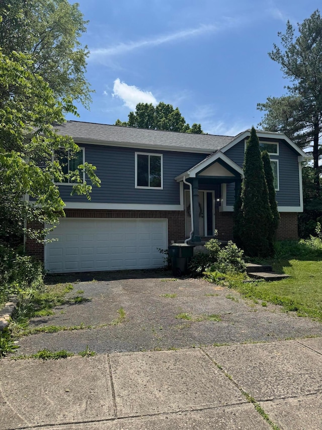 3751 Dolomite Dr, Columbus, OH 43230 - raised ranch featuring brick siding, an attached garage, asphalt driveway, and a shingled roof