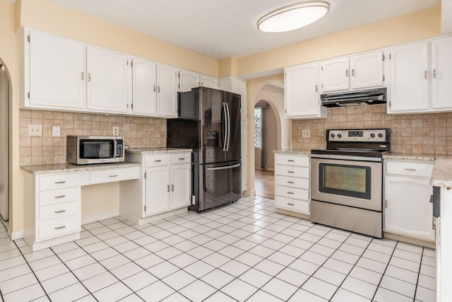 5946 Lisa St, Columbus, OH 43231 - kitchen featuring appliances with stainless steel finishes, arched walkways, under cabinet range hood, tasteful backsplash, and white cabinets