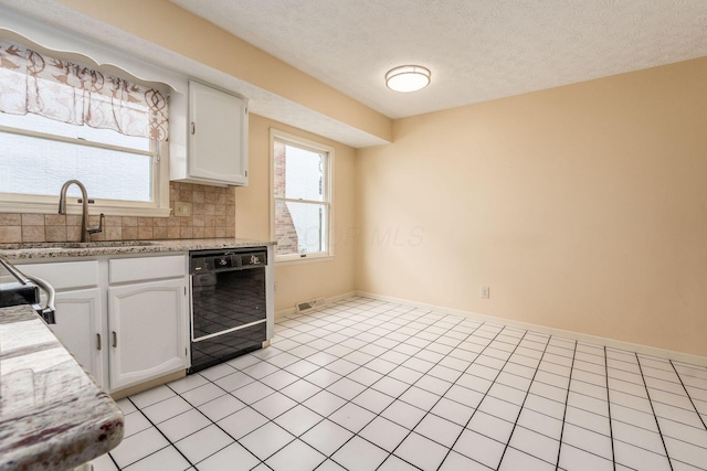 5946 Lisa St, Columbus, OH 43231 - kitchen featuring black dishwasher, white cabinets, backsplash, plenty of natural light, and a textured ceiling