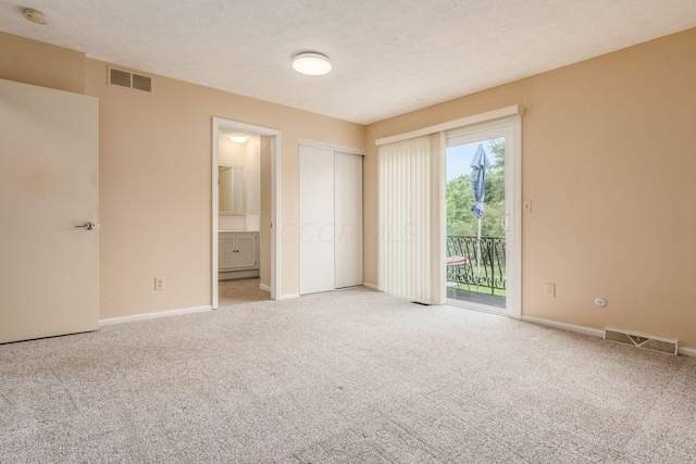 5946 Lisa St, Columbus, OH 43231 - unfurnished bedroom featuring access to exterior, light carpet, ensuite bath, a closet, and a textured ceiling