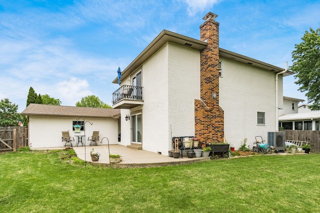 5946 Lisa St, Columbus, OH 43231 - rear view of house featuring a balcony, a patio, a chimney, and stucco siding
