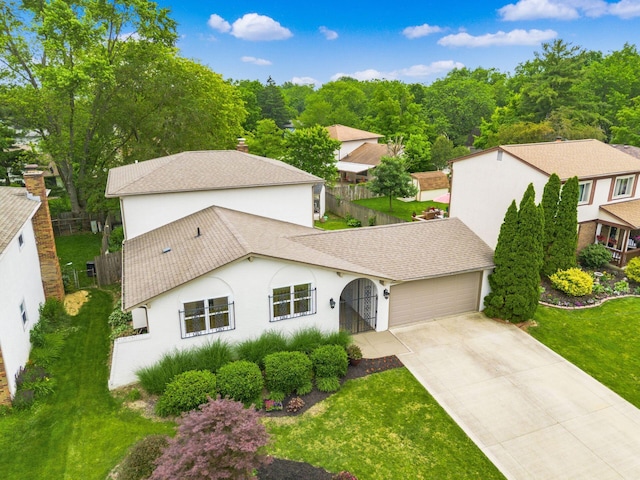 5946 Lisa St, Columbus, OH 43231 - view of front of house with stucco siding, a garage, concrete driveway, roof with shingles, and a residential view