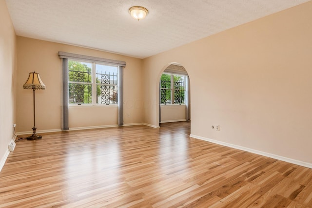 5946 Lisa St, Columbus, OH 43231 - spare room with light wood finished floors, arched walkways, and a textured ceiling