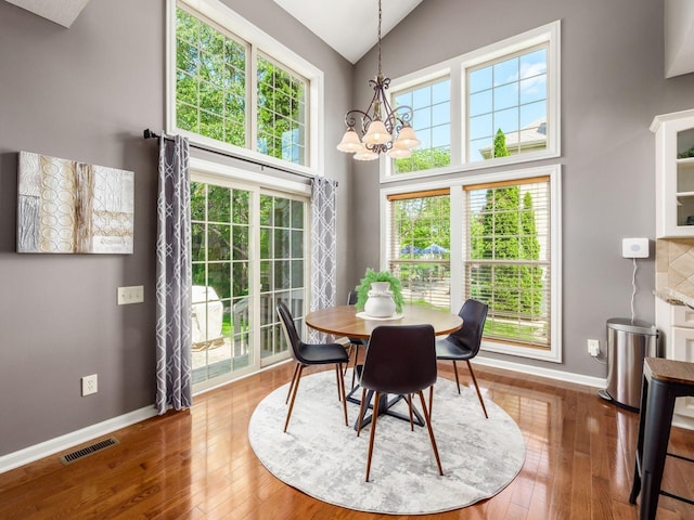 6628 Dalmore Ln, Dublin, OH 43016 - dining room with a chandelier, baseboards, hardwood / wood-style flooring, and high vaulted ceiling
