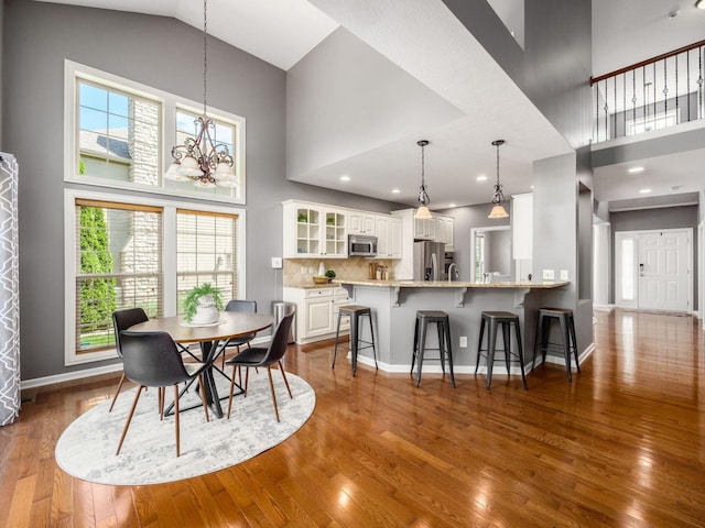 6628 Dalmore Ln, Dublin, OH 43016 - dining area with a towering ceiling, dark wood-type flooring, baseboards, and a chandelier