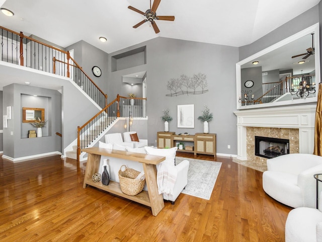 6628 Dalmore Ln, Dublin, OH 43016 - living area featuring ceiling fan, high vaulted ceiling, stairway, wood finished floors, and a tiled fireplace
