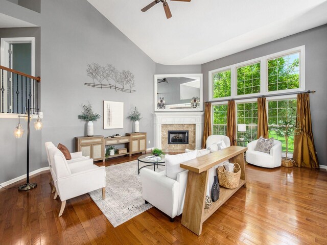 6628 Dalmore Ln, Dublin, OH 43016 - living room featuring a ceiling fan, a fireplace, baseboards, hardwood / wood-style flooring, and high vaulted ceiling