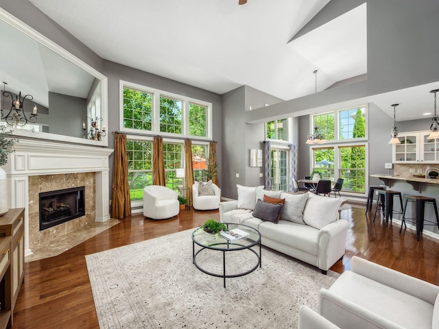 6628 Dalmore Ln, Dublin, OH 43016 - living room with high vaulted ceiling, wood finished floors, healthy amount of natural light, a tiled fireplace, and a chandelier