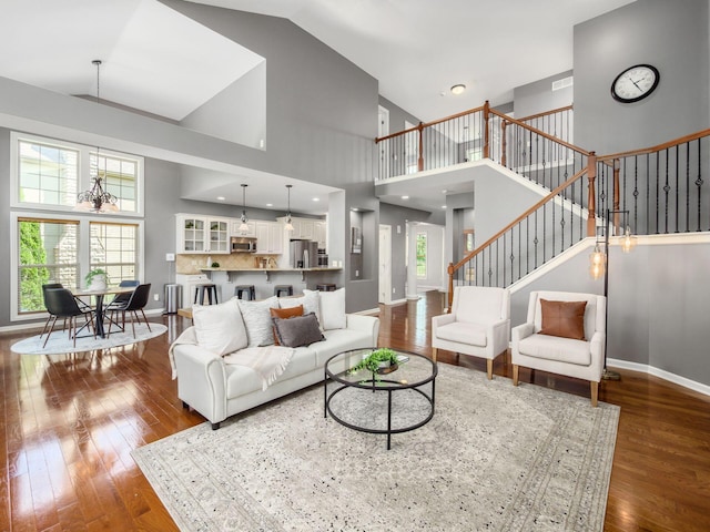 6628 Dalmore Ln, Dublin, OH 43016 - living area featuring dark wood-type flooring, a high ceiling, stairway, and baseboards