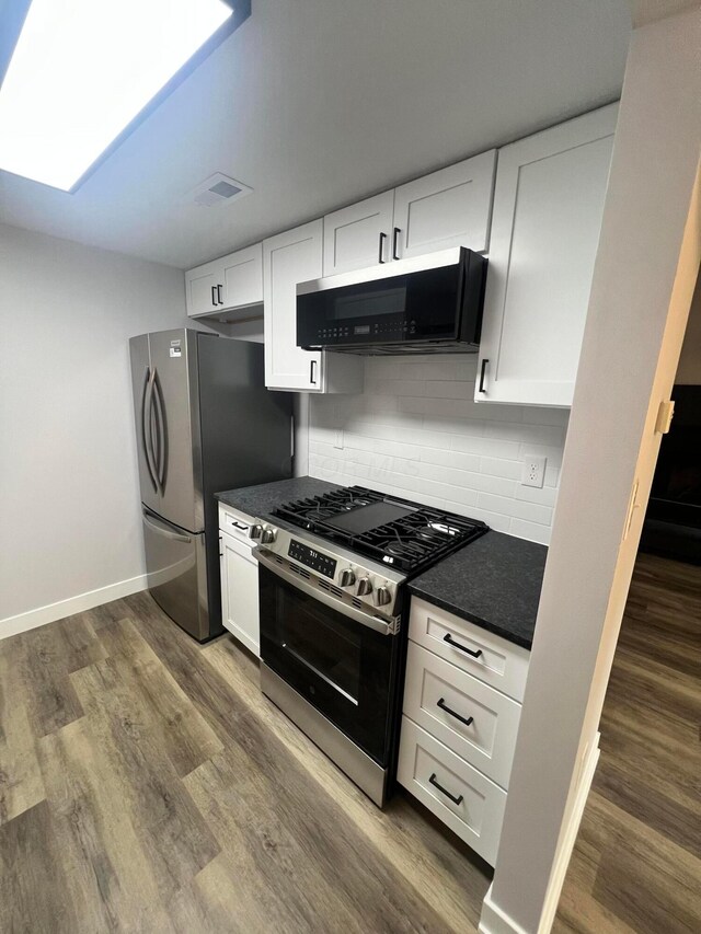 139 Corbins Mill Dr, Dublin, OH 43017 - kitchen featuring stainless steel appliances, white cabinets, backsplash, dark wood finished floors, and baseboards