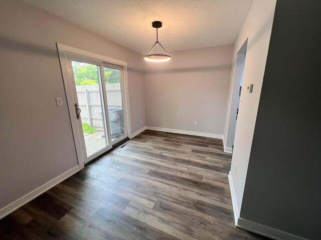 139 Corbins Mill Dr, Dublin, OH 43017 - unfurnished dining area featuring dark wood finished floors, baseboards, and a textured ceiling