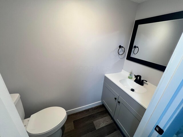 139 Corbins Mill Dr, Dublin, OH 43017 - half bathroom with toilet, wood finished floors, vanity, and baseboards