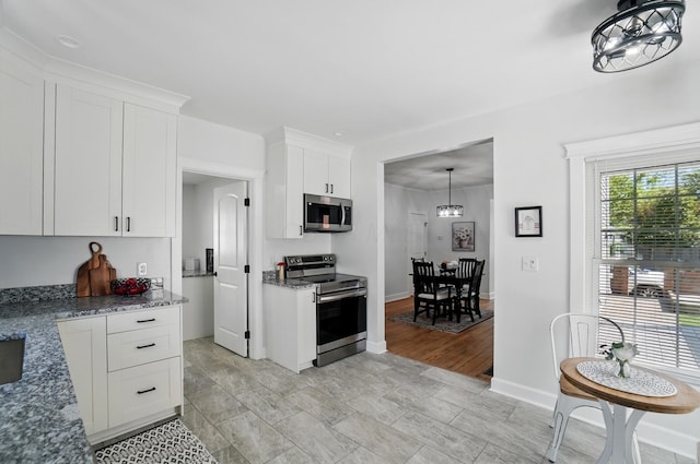 446 E Beck St, Columbus, OH 43206 - kitchen featuring stainless steel appliances, white cabinets, stone countertops, and baseboards