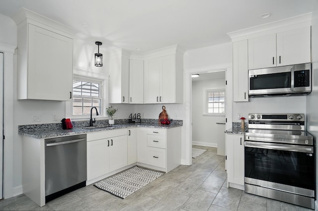 446 E Beck St, Columbus, OH 43206 - kitchen with stainless steel appliances, a sink, light stone countertops, and white cabinets