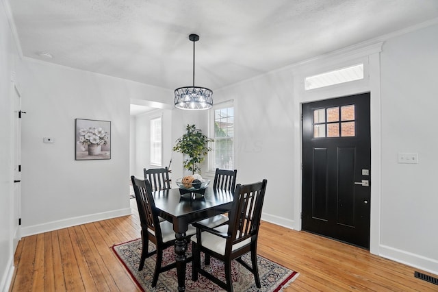 446 E Beck St, Columbus, OH 43206 - dining space featuring a chandelier, light wood-style floors, baseboards, and ornamental molding