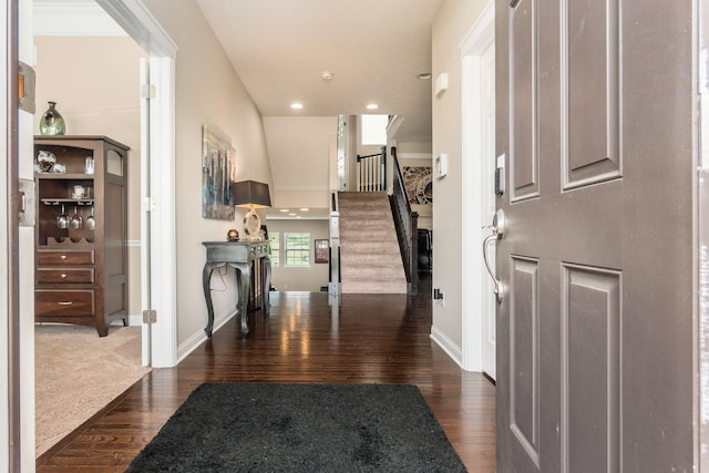 foyer with dark wood-style flooring, stairs, baseboards, and recessed lighting