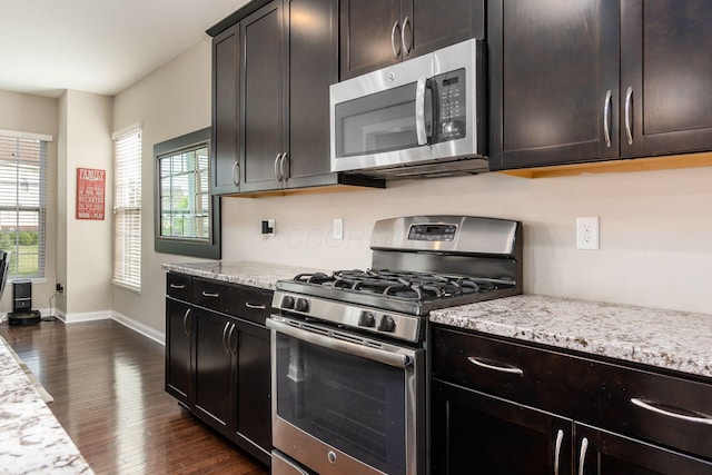 kitchen featuring appliances with stainless steel finishes, baseboards, dark wood-style floors, and healthy amount of natural light