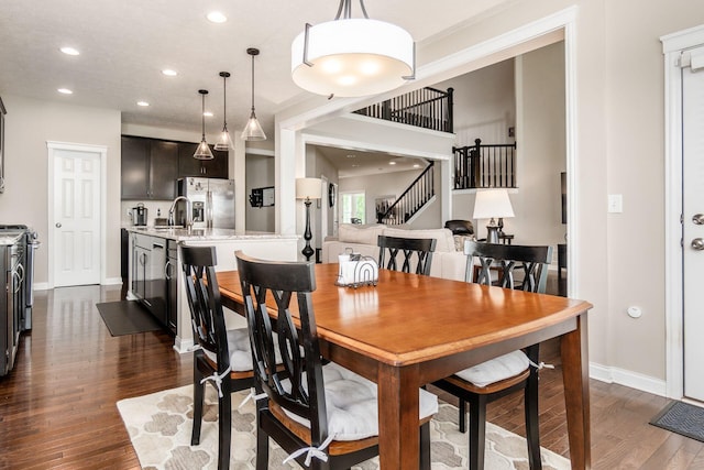 dining area with stairway, dark wood-type flooring, baseboards, and recessed lighting