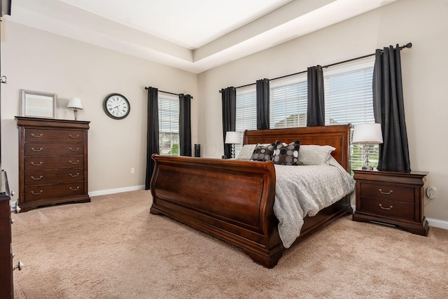 bedroom featuring light colored carpet and baseboards