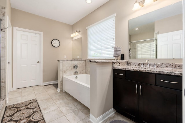bathroom featuring a stall shower, a bath, baseboards, and vanity